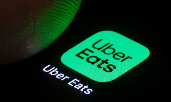 Icono iluminado de la app Uber Eats en la pantalla de un celular, representando a los trabajadores de plataformas digitales.