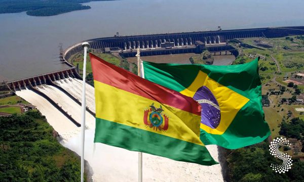 Banderas de Brasil y Bolivia frente a una represa hidroeléctrica, en referencia al proyecto binacional propuesto en el río Madeira.