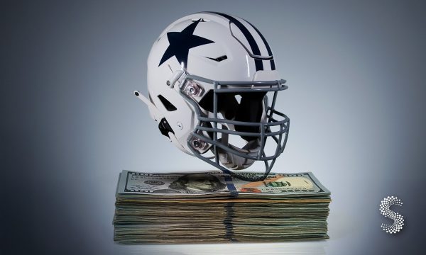 Casco de los Dallas Cowboys sobre un fajo de billetes de 100 dólares, simbolizando su liderazgo como franquicia deportiva más valiosa del mundo.