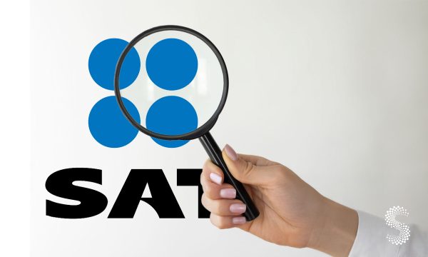 Logo del SAT visto a través de una lupa, simbolizando la fiscalización de empresas en México.