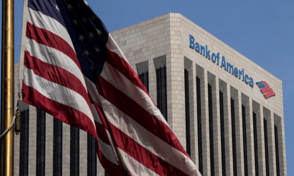 Edificio de Bank of America en Estados Unidos con la bandera nacional al frente.