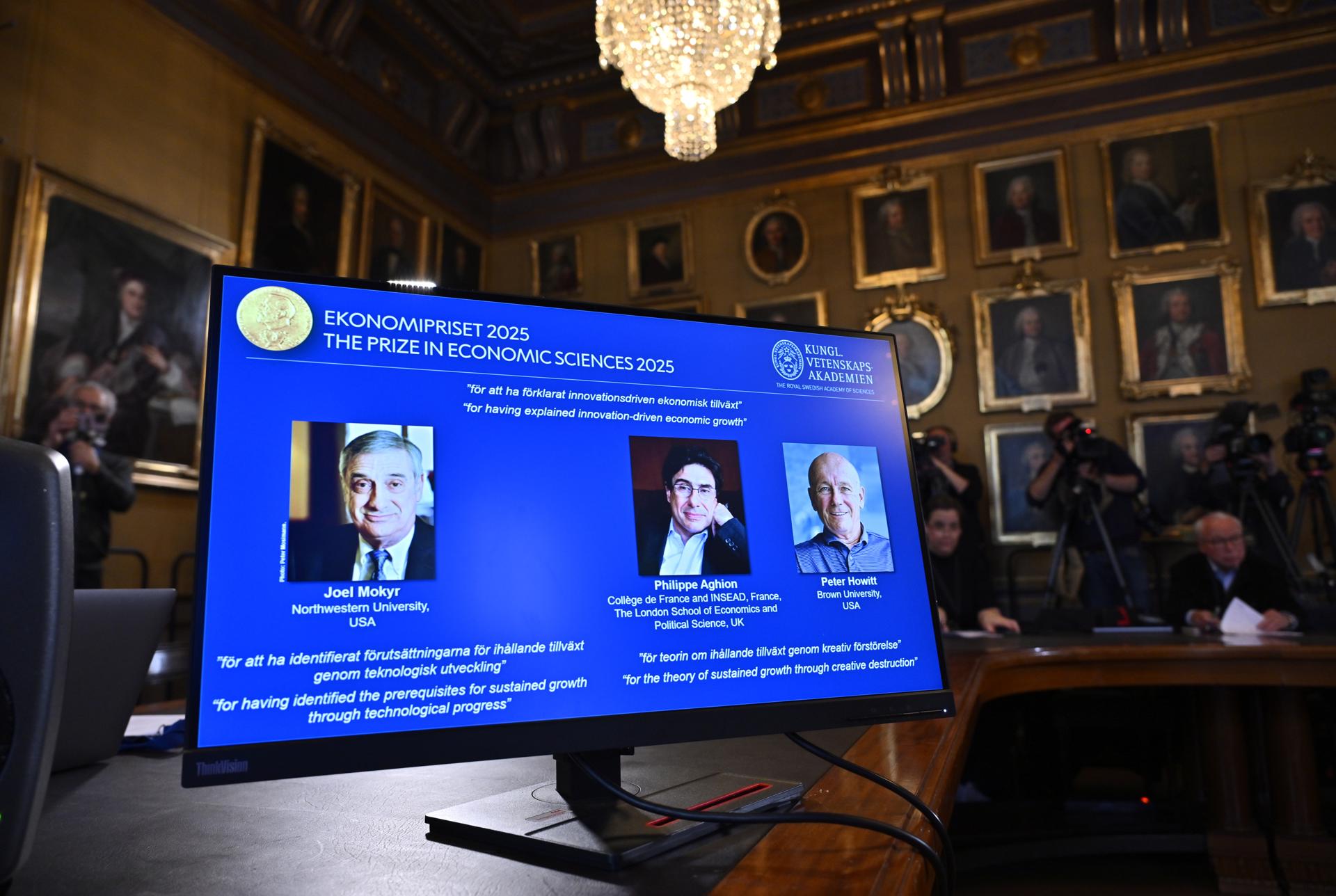 Pantalla con los retratos de Joel Mokyr, Philippe Aghion y Peter Howitt, ganadores del Premio Nobel de Economía 2025, durante el anuncio en Estocolmo.
