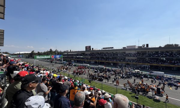 Vista panorámica del Autódromo Hermanos Rodríguez durante el Gran Premio de México de Fórmula 1, con gradas llenas y equipos preparando la salida en la pista.