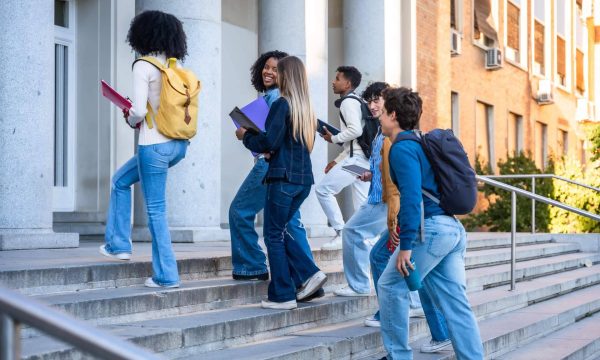 Estudiantes suben las escaleras de una universidad como símbolo de la movilidad estudiantil entre México y Canadá.